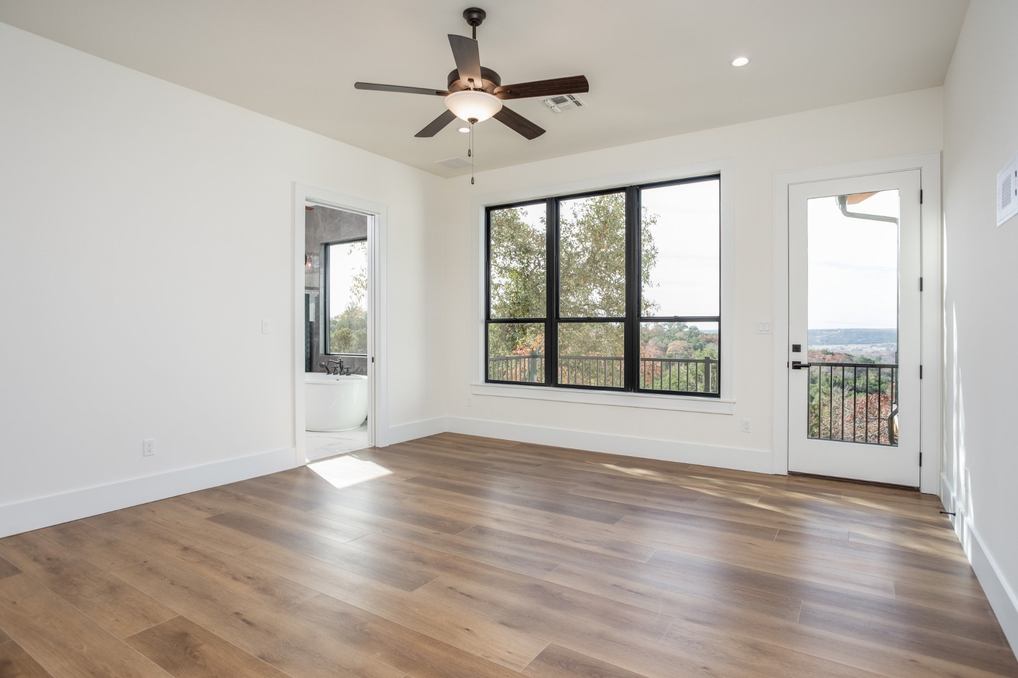 Black steel windows framing a hill country view